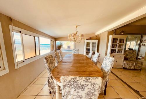 a dining room with a wooden table and chairs at Villa Maimouna les pieds dans l'eau in Saint-Pierre