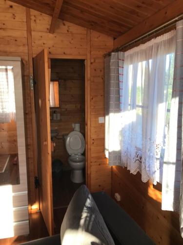 uma casa de banho com WC num chalé de madeira em Sianowskie Ranczo em Sianów