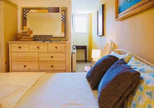 a bedroom with a bed with a dresser and a mirror at Villa “Alexis&Coco” traditional house in Tríkorfon