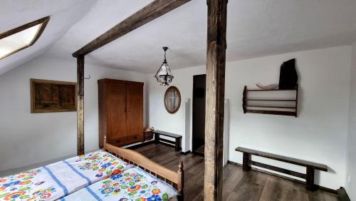 um quarto com uma cama de madeira e um banco em Přemyslovský dvůr em Slezské Pavlovice