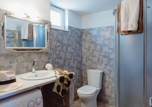 een badkamer met een toilet, een wastafel en een spiegel bij Villa “Alexis&Coco” traditional house in Tríkorfon