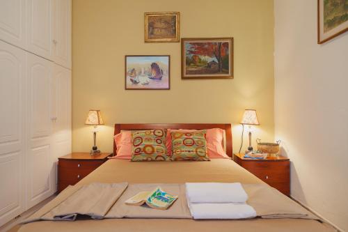 a bedroom with a bed with two lamps and two towels at Villa “Alexis&Coco” traditional house in Tríkorfon