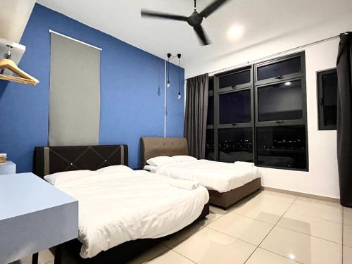 une chambre avec deux lits et un mur bleu dans l'établissement Sunset House-Atlantis Residence, à Malacca