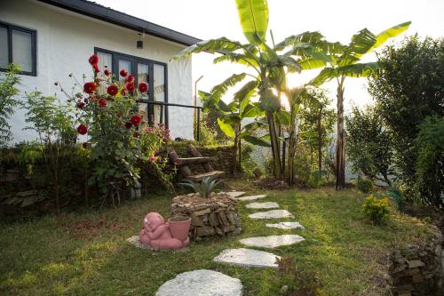 a garden with a stone path in front of a house at Raniban Retreat in Pokhara
