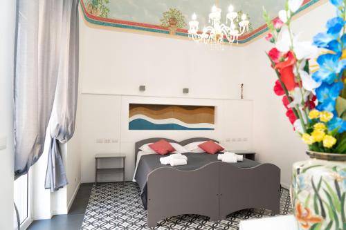 1 dormitorio con 1 cama y un jarrón con flores en Zagara e Lumia en Catania