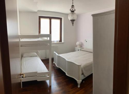 Dormitorio blanco con cama y estante en Condominio tigli, en Cavalcaselle
