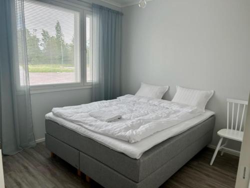 Soda Home - Hillside House - 24h check in في Närpiö: سرير كبير في غرفة نوم مع نافذة