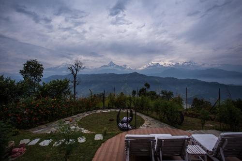 a playground with a swing and mountains in the background at Raniban Retreat in Pokhara