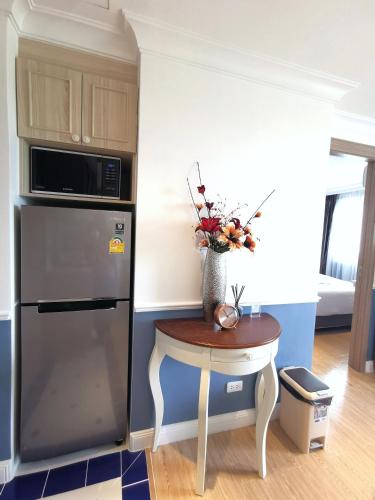 a kitchen with a small table and a refrigerator at C24 Seven Seas Cote DAzur Luxury Private in Na Jomtien