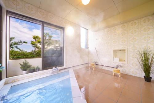 a swimming pool in a room with a large window at The miracle of blue hot spring in Beppu