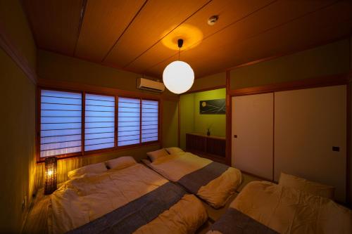 1 dormitorio con 2 camas y ventana grande en The miracle of blue hot spring en Beppu