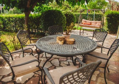 a patio table with chairs and a cactus on it at Villa “Alexis&Coco” traditional house in Tríkorfon