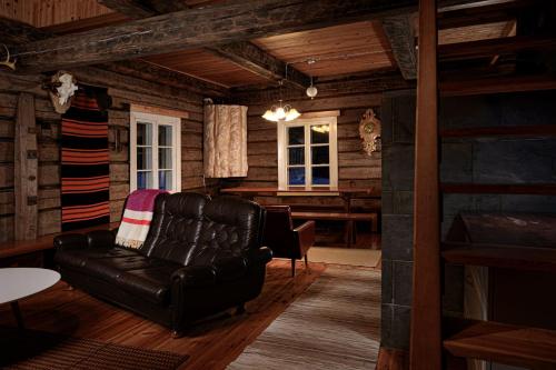 a living room with a leather couch and a table at Kainuun Luontoretket in Hossa
