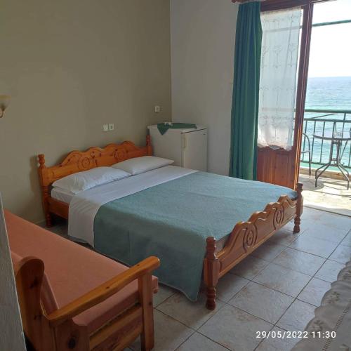 a bedroom with two beds and a view of the ocean at Nissaki Guesthouse in Keramídhion