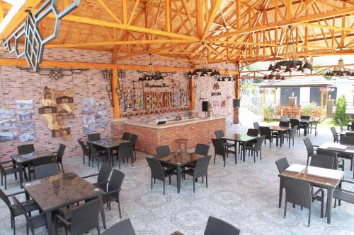 a restaurant with tables and chairs and a brick wall at Macara Sheki City Hotel in Sheki