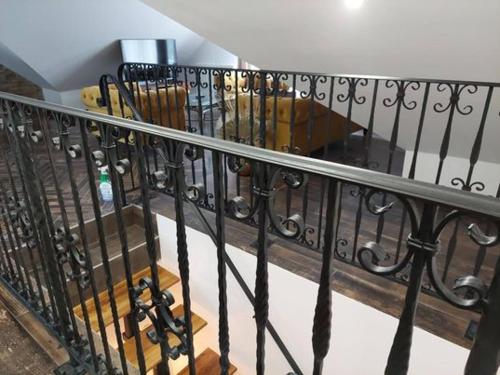 a staircase with a wrought iron railing and a table at Dr Becsey Luxury Apartman in Békéscsaba