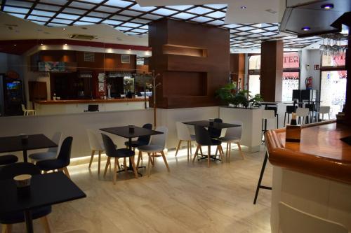 um restaurante com mesas e cadeiras e um bar em Hotel Alisi em Aranda de Duero