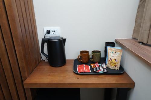 a table with a coffee maker and mugs on it at Sweet69apartments JP in Niš