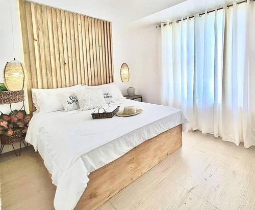 MarigondonにあるNEW Luxury Suite with pool and Netflix near Airportの白いベッドルーム(大型ベッド1台、トレイ付)
