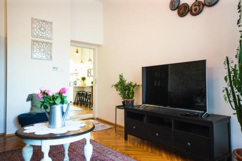 a living room with a tv and a coffee table at Villa Inda Rooms in Eger