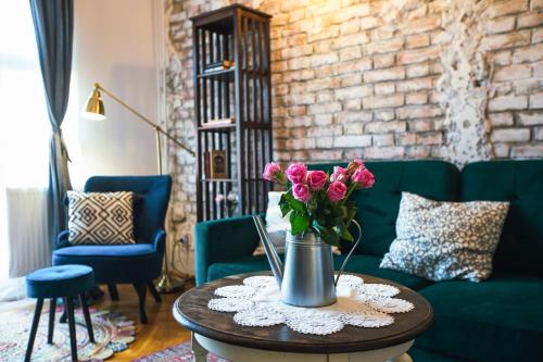 a living room with a vase of flowers on a table at Villa Inda Rooms in Eger