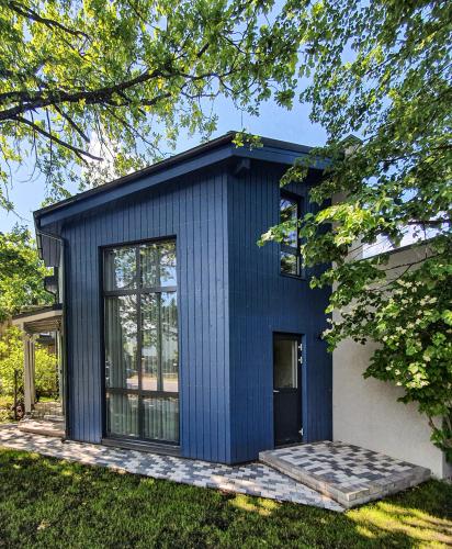 Una pequeña casa azul en lo alto de un patio. en Kotedža “Saules osta”, en Saulkrasti