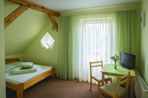 - une chambre avec un lit, une table et une fenêtre dans l'établissement Viesu māja Jānis, à Madona