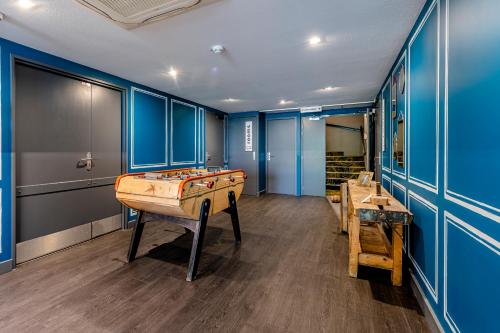 a room with a pool table and blue walls at Greet Hotel Bordeaux Floirac Arena in Floirac