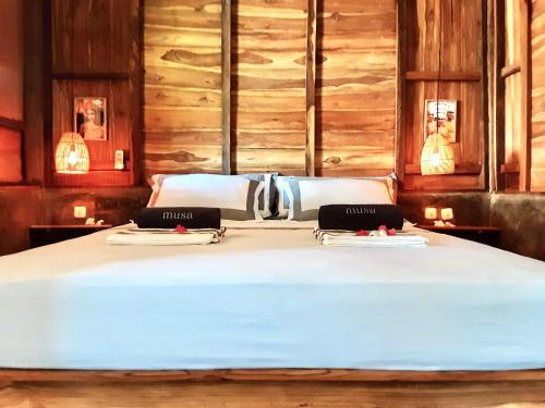 a bed with two towels on top of it at Musa Bintang Villas and Bungalows Gili Air in Gili Air