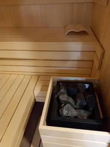 a sauna with a tub filled with rocks at B&B family room Tubej in Bohinj