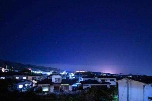 a view of a city at night with lights at Taketori Roten -House with open-air bath in Beppu