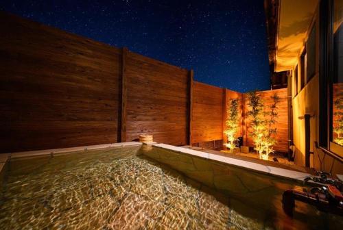 a swimming pool in a house at night at Taketori Roten -House with open-air bath in Beppu