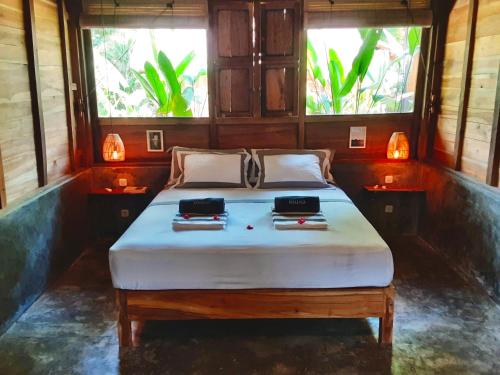 a bed in a room with two bags on it at Musa Bintang Villas and Bungalows Gili Air in Gili Air
