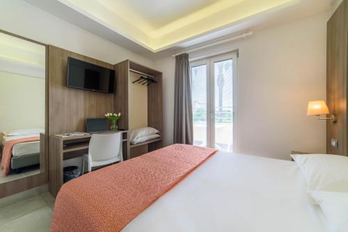 a hotel room with a bed and a desk with a computer at Hotel La Mela in Varcaturo