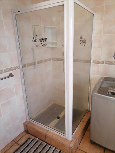 a shower with a glass door in a bathroom at Inni hoeki in Sasolburg