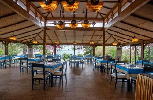 un comedor con mesas y sillas azules en Stone Water Eco Resort en Bogmalo