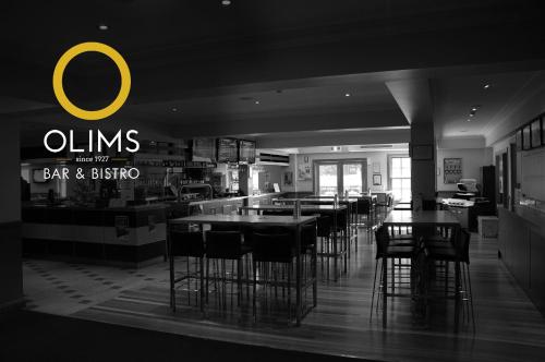 a dining room with tables and chairs in a restaurant at Mercure Canberra in Canberra