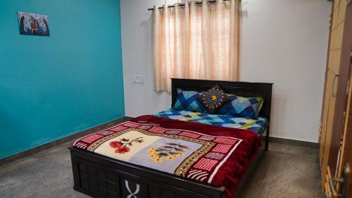 a small bedroom with a bed with a colorfulspread at Padmanivas in Bangalore