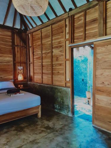 a bedroom with a bed and a large window at Musa Bintang Villas and Bungalows Gili Air in Gili Air