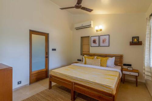 a bedroom with a bed and a ceiling fan at Beyond The Blue Door by VEO - Part of StayVista in Mahabaleshwar