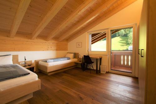 1 dormitorio con cama, escritorio y ventana en Mountain Penthouse Top 8 & 9 en Fügen