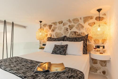 a bedroom with a bed with a stone wall at Naxian Spirit Inn in Naxos Chora