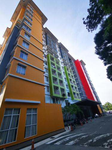 a yellow building with green windows on a street at Bayou Lagoon Park Resort in Melaka
