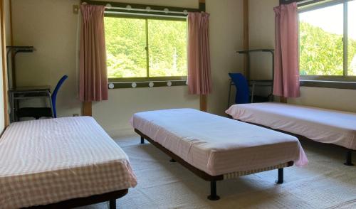 a room with three beds and a window at 星降るゲストハウスー奥琵琶湖マキノ1日1組限定の1棟貸しプランー in Kaizu