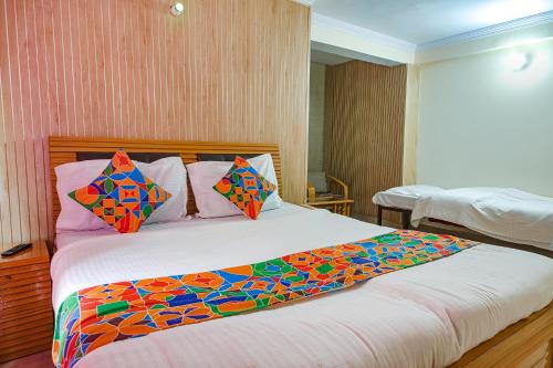 a bedroom with a large bed with colorful pillows at FabExpress Sapphire in Mussoorie