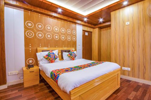 a bedroom with a large bed with a wooden wall at FabExpress Sapphire in Mussoorie