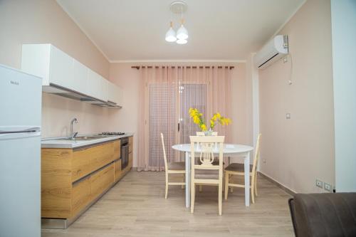 une cuisine avec une table ornée de fleurs jaunes dans l'établissement Villa Pulo, à Tragjas