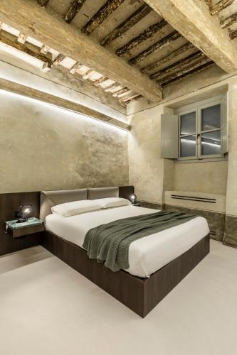 a bedroom with a large bed in a room at CHIAROMANNI SUITE in Arezzo