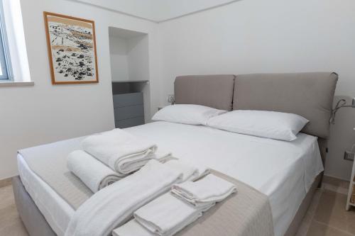 a white bed with white towels on top of it at Relais I Secolari in Selva di Fasano