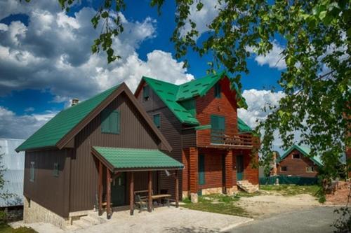 una grande casa con un tetto verde sopra di essa di Guest House MIKA a Žabljak
